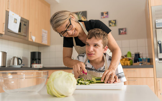 Junge kocht gemeinsam mit seiner Betreuerin im SBBZ Baindt