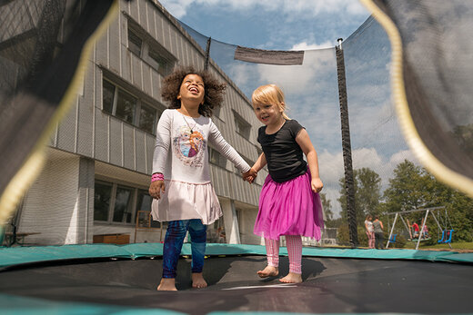 Zwei Mädchen springen Trampolin