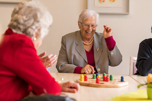 Seniorinnen spielen zusammen Mensch ärgere Dich nicht 