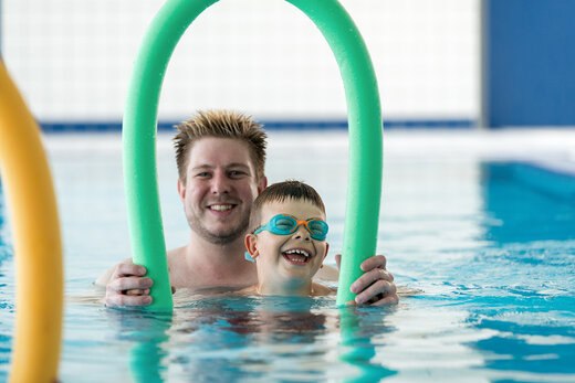 Betreuer schwimmt gemeinsam mit Kind