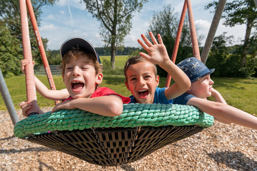 Kinder der Stiftung St. Franziskus schaukeln und haben Spaß