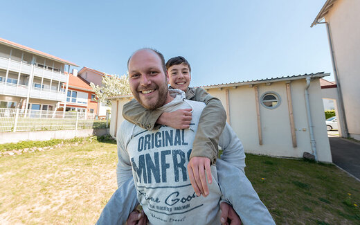 Betreuer trägt Junge auf dem Rücken 