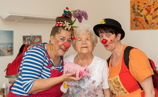 Seniorin mit zwei Clowns