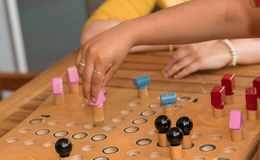 Betreuer und Kinder spielen gemeinsam Mensch ärgere Dich nicht